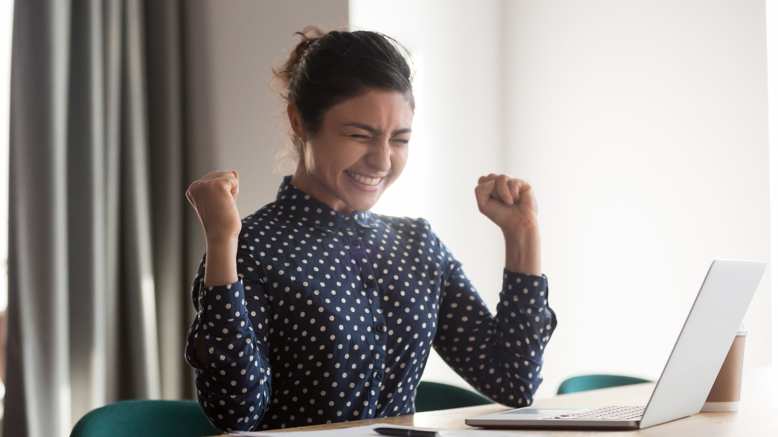 Excited happy indian employee celebrating success at work