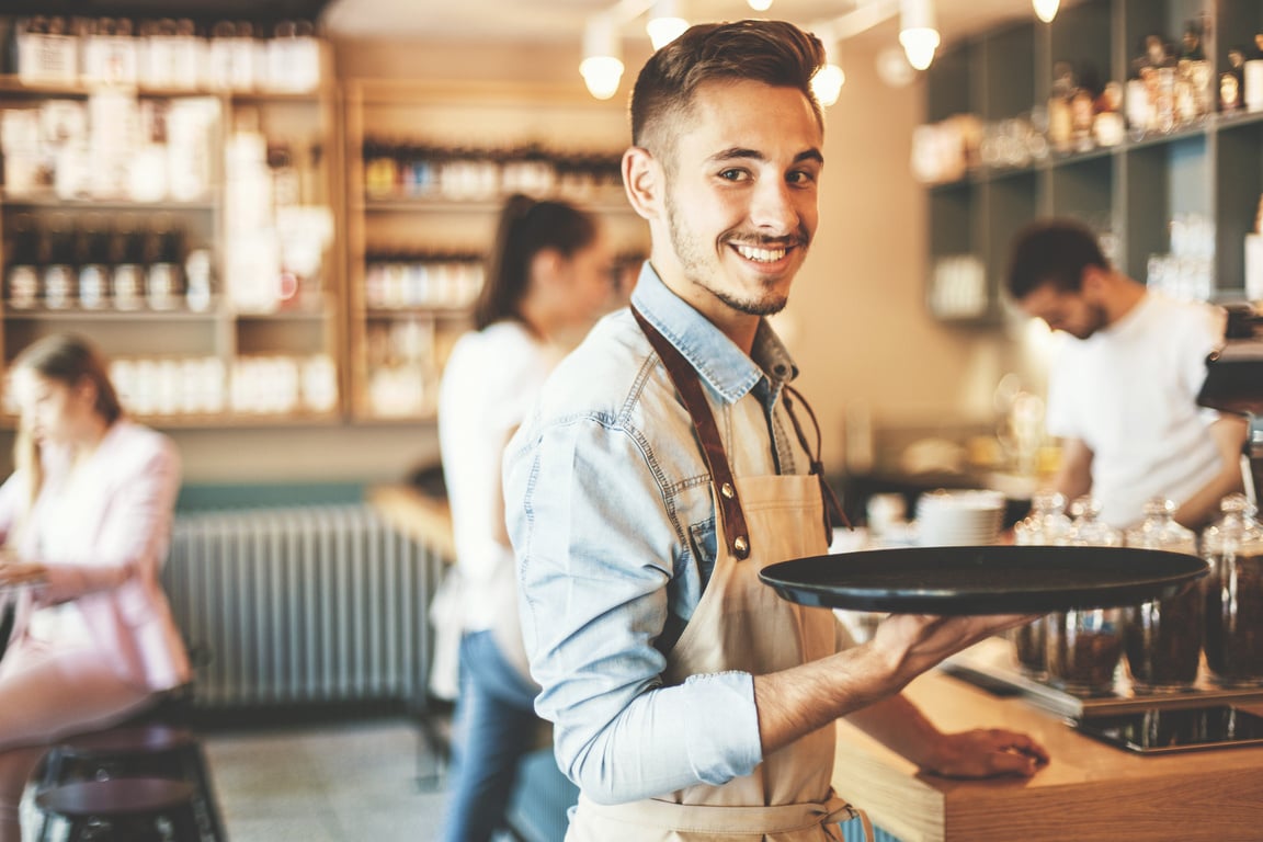 Young waiter serving